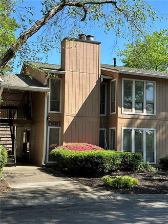 Front view of a two-story building with large windows and wooden exterior siding.