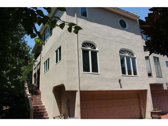 Front view of a multi-story house with large windows and an attached garage.