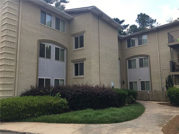 Front view of a three-story brick building with multiple windows.
