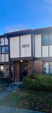 Front view of a two-story house with brick and panel siding.