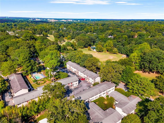 Aerial view showing multiple buildings surrounded by trees and greenery.