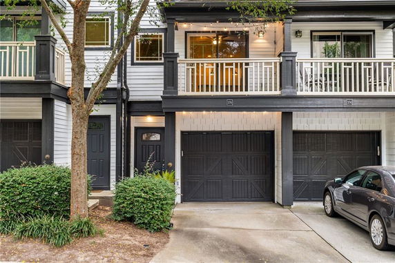 Front view of a two-story townhouse with balconies and garages.