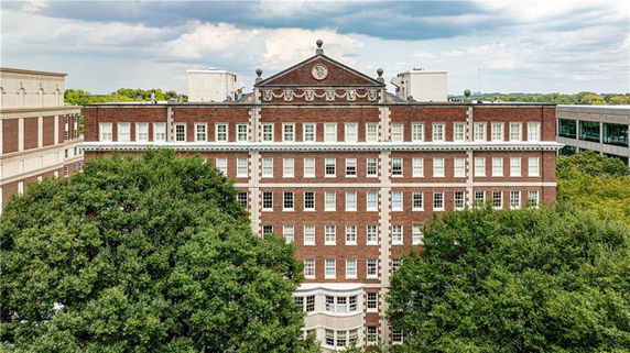 Front view of a multi-story brick building with decorative architectural elements.