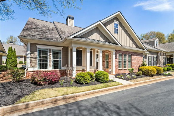 Front view of a single-story house with a gabled roof and brick exterior.