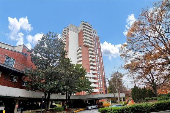 Front view of a high-rise residential building with multiple balconies.