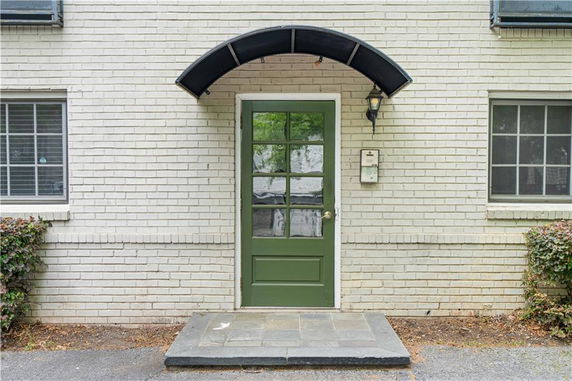 Front view of a house with a green door and awning.