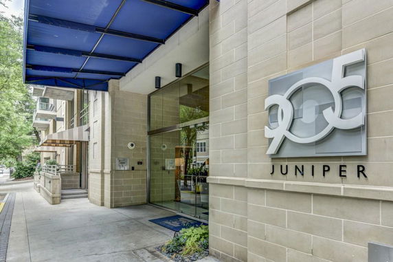 Front view of a modern building entrance with a sign reading '905 Juniper'.