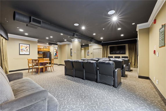 Indoor recreation room with rows of leather seats facing a large screen.