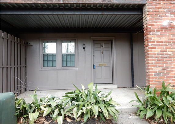 Front view of a house with a covered entrance and brick exterior.
