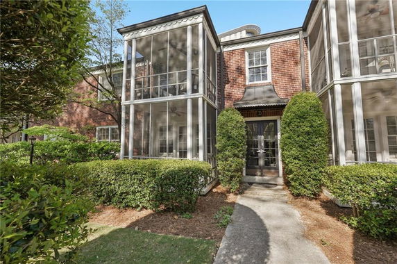 Front view of a two-story brick building with screened porches.