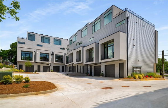 Front view of a multi-level modern townhouse complex with garages.
