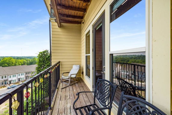 Balcony view overlooking residential area and greenery.