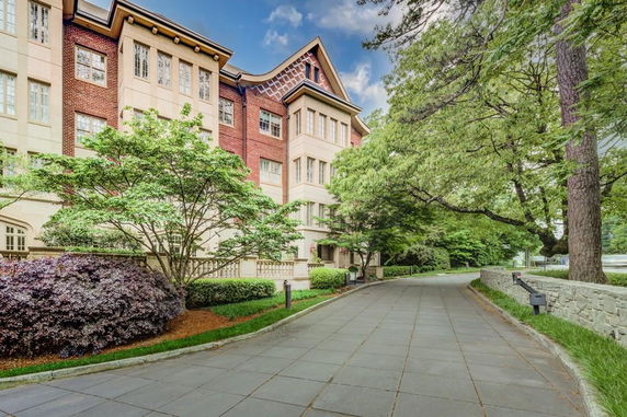 Front view of a multi-story residential building with brick and stone facade.