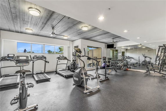 Interior view of a modern gym with fitness equipment and large mirrors.