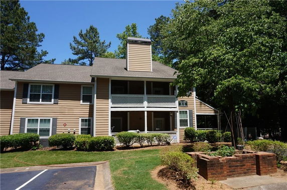 Front view of a two-story house with a balcony and chimney.
