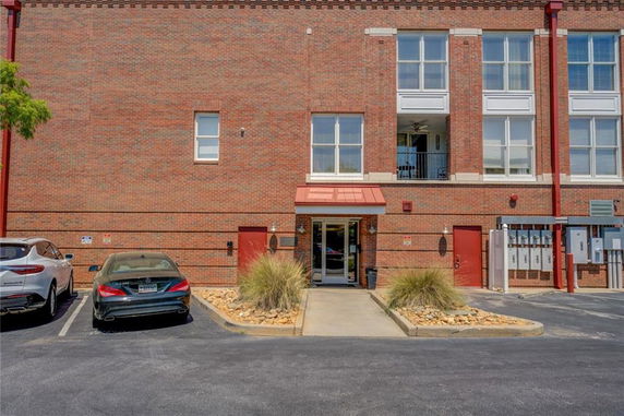 Front view of a brick building with large windows and a central entrance.