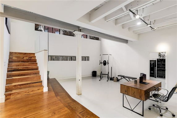 Interior space with exercise equipment and a desk.