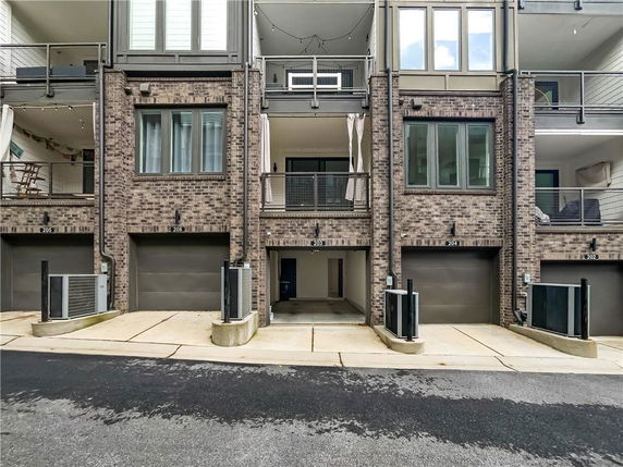 Front view of a multi-story brick residential building with multiple garages.