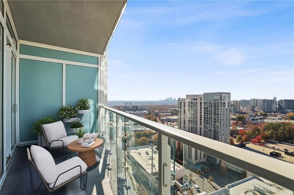 High-rise balcony with outdoor seating and a panoramic urban view.