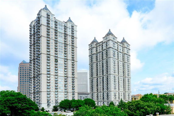 Front view of two tall apartment buildings with multiple balconies.