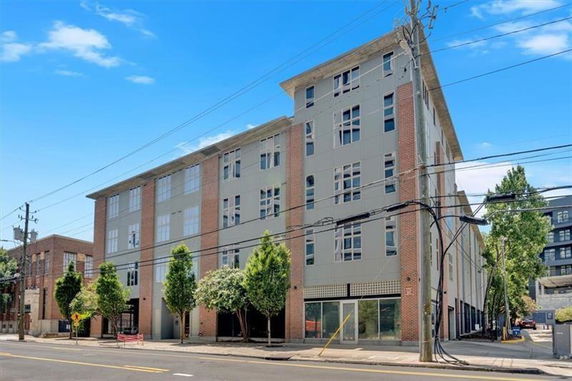 Front view of a four-story building with large windows and a brick exterior.
