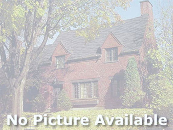 Front view of a two-story brick house with a pitched roof and chimney.