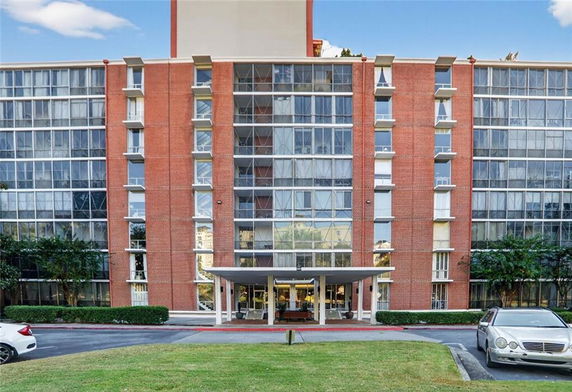Front view of a multi-story building with a glass facade and central entrance.