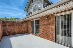 Rooftop view featuring brick walls and sliding glass doors.