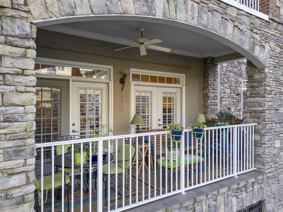 Front view of a stone-clad building with a small balcony.
