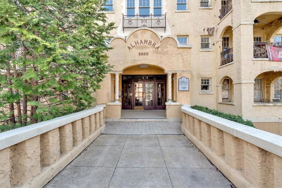 Front view of a building with arched entryway and multiple windows.