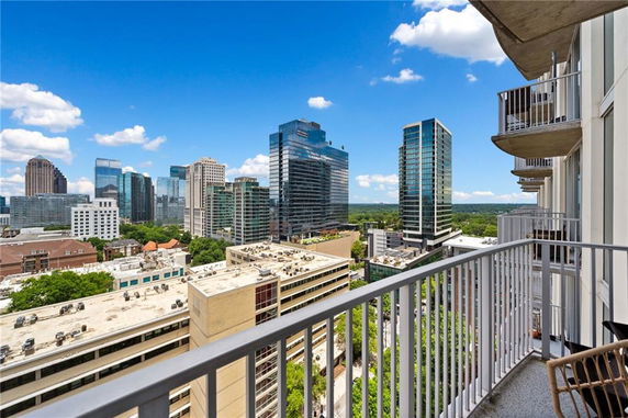 Panoramic view from a balcony overlooking a city skyline with tall buildings.