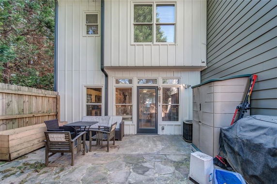 Outdoor patio area with seating and storage units adjacent to a house.