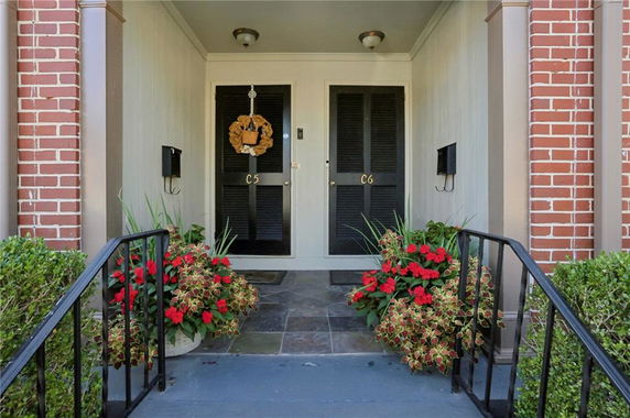Front view of an entryway with dual doors and brick accents.