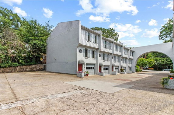 Front view of a multi-story townhouse complex with garages.