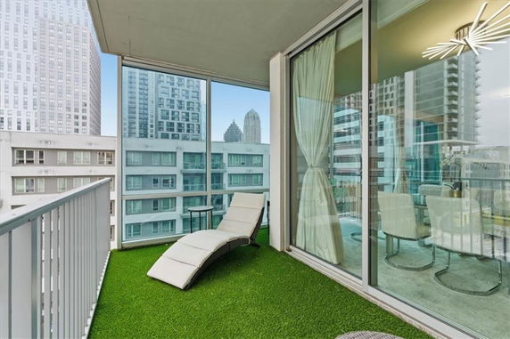 Balcony view with cityscape background and outdoor seating area.