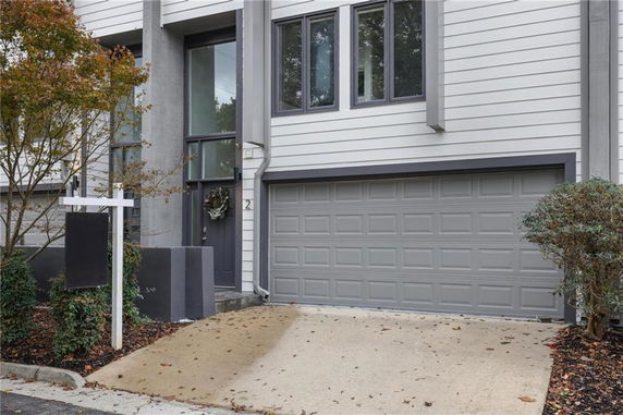 Front view of a modern house with a two-car garage and a paved driveway.