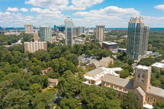 Panoramic view of a cityscape with multiple tall buildings and a cathedral.