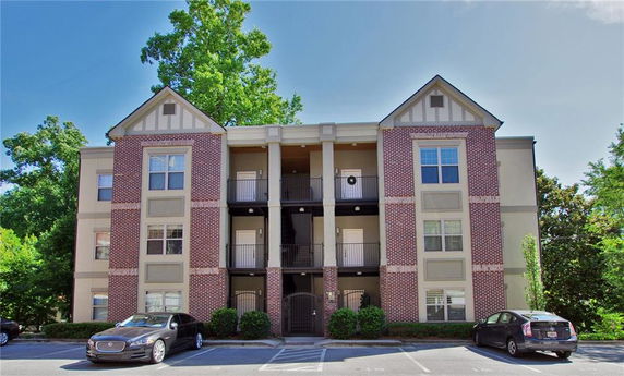 Front view of a multi-story apartment building with brick and siding exterior.