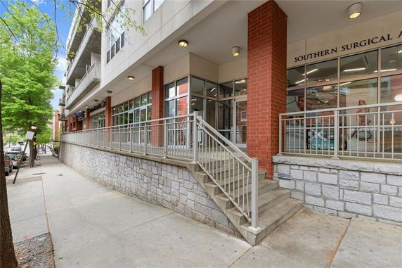 Front view of a commercial building with glass windows and brick columns.