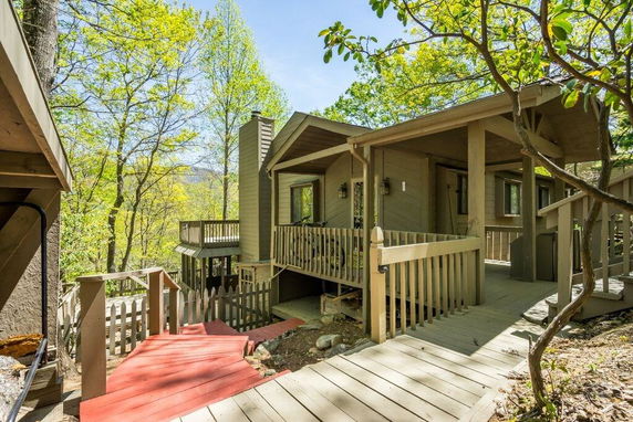 Front view of a multi-level house with a wooden exterior and surrounding decking.