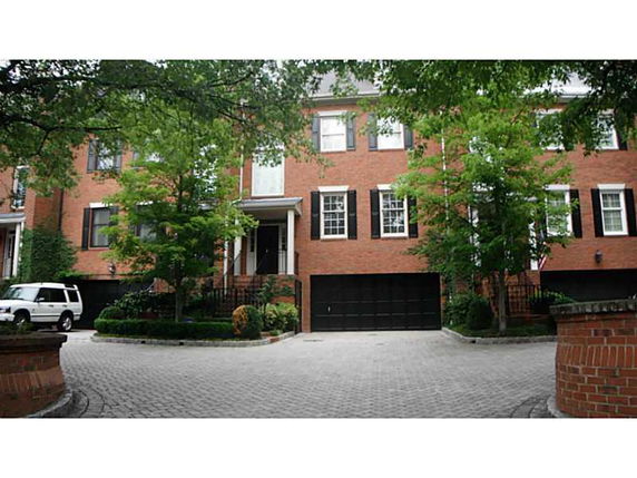 Front view of a multi-story brick house with a double garage.