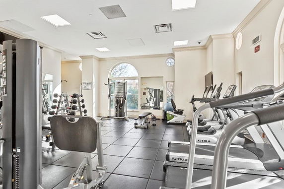 Indoor gym area with exercise equipment and large windows.