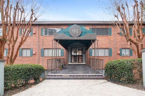 Front view of a brick apartment building with an entrance canopy.