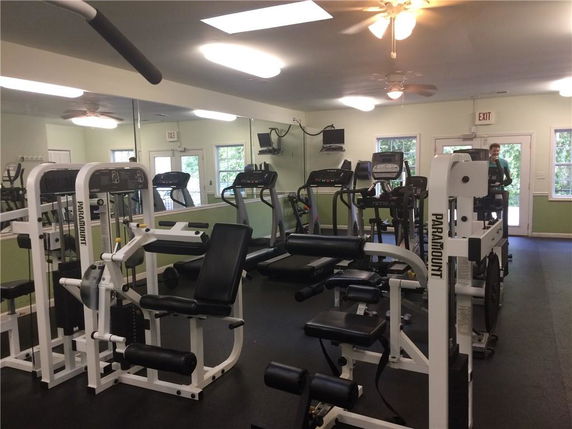 Indoor gym area with various exercise machines and equipment.