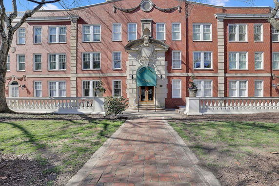 Front view of a multi-story brick building with symmetrical windows and a central entrance.
