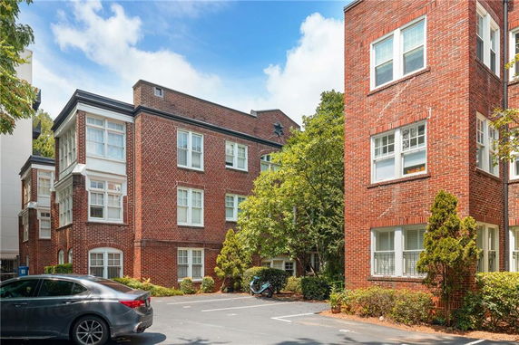 Front view of a brick apartment building with multiple windows.
