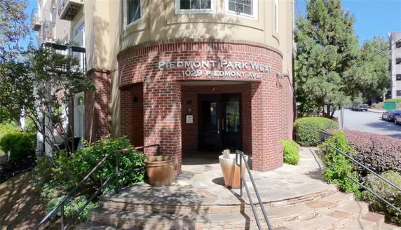 Front view of a building entrance with brick walls and a rounded design.