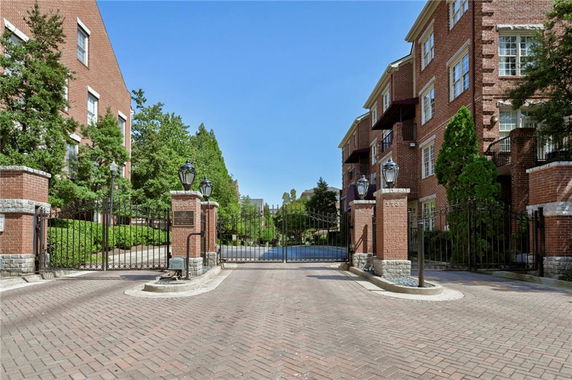 Front view of a gated residential complex with brick buildings.