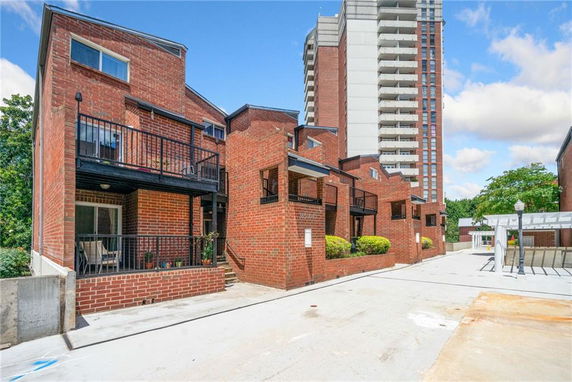 Front view of a brick apartment building with balconies.