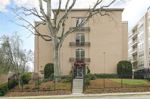 Front view of a multi-story residential building with a central entrance and balconies.
